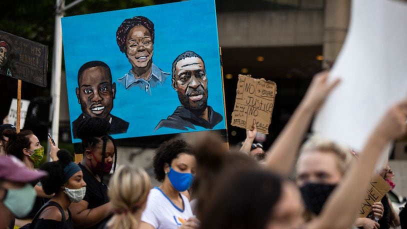LOUISVILLE, KY - JUNE 05:   Protesters carry a painting of (L-R) Ahmaud Arbery, Breonna Taylor and George Floyd while marching on June 5, 2020 in Louisville, Kentucky. Protests across the country continue into their second weekend after recent police-related incidents resulting in the deaths of African-Americans Breonna Taylor in Louisville and George Floyd in Minneapolis, (Photo by Brett Carlsen/Getty Images)
