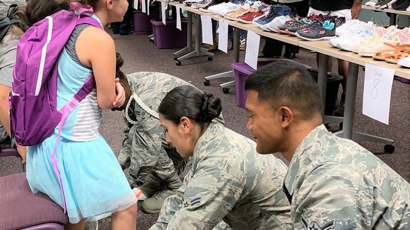 Airmen check the fit of a child’s new shoes Aug. 8 at the Montgomery County Children’s Center. Young personnel from the 88th Security Forces Squadron and the United States Air Force School of Aerospace Medicine at Wright-Patterson Air Force Base helped about 160 kids find their perfect size and style among the brand-new pairs donated by the base’s Chapel community. (Contributed photo)