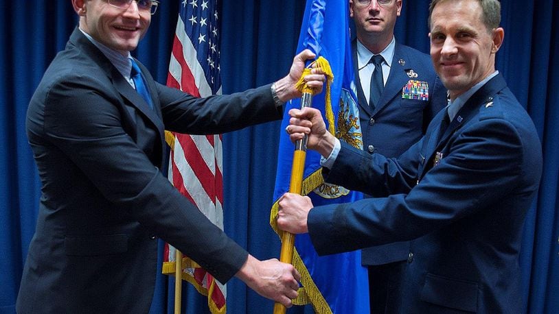 Dr. Will Roper (left), U.S. Air Force assistant secretary for Acquisition, Technology and Logistics, presents Brig. Gen. John P. Newberry with a guidon, May 31 as Newberry assumes leadership of the directorate during a ceremony at Wright-Patterson Air Force Base. Senior Master Sgt. Shawn R. Akers, Tanker Directorate superintendent stands by to take the guidon from Newberry. (U.S. Air Force photo/R.J. Oriez)