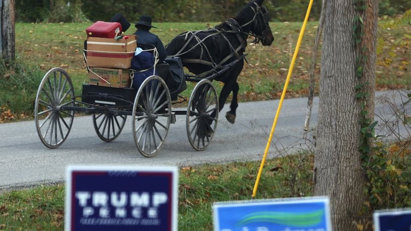 An couple ride in a horse and buggy down Mount Zwingli road in Fairfield County, Ohio, on October 27, 2016. (Columbus Dispatch photo by Brooke LaValley)
