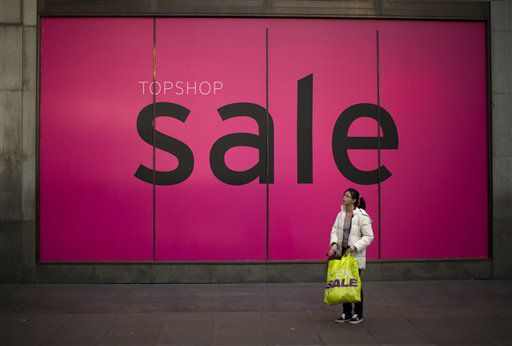 A shopper stands by a sale sign on a store window during the traditional Boxing Day sales on Oxford Street in London.