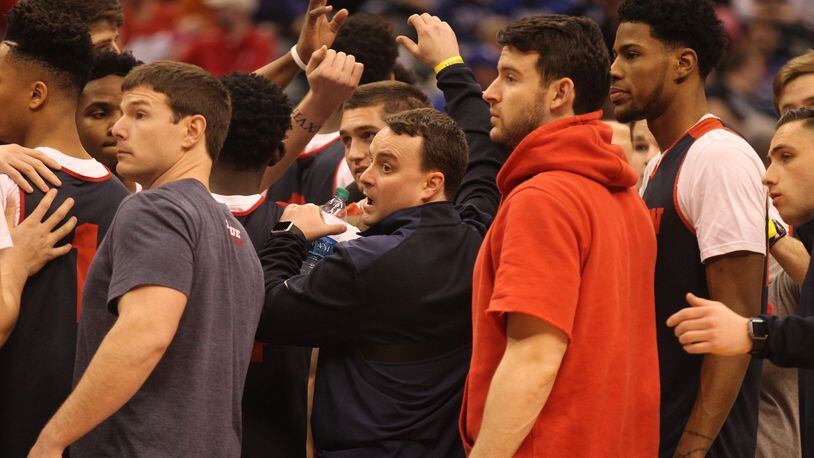 Players huddle around Dayton coach Archie Miller after practice on Thursday, March 16, 2017, at Bankers Life Fieldhouse in Indianapolis. David Jablonski/Staff