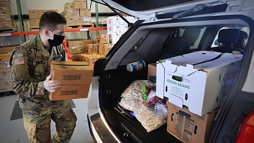 A member of the National Guard loads fresh food into the back of a vehicle at The Foodbank Thursday. MARSHALL GORBYSTAFF