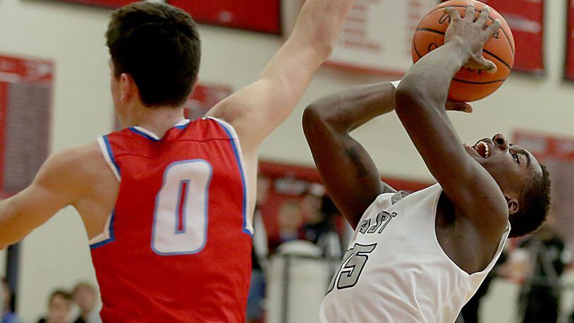 Lakota East guard Jarrett Cox shoots as Kings guard Gabe Stacy tries to block his attempt during their Division I sectional game at Lakota West on March 1. CONTRIBUTED PHOTO BY E.L. HUBBARD