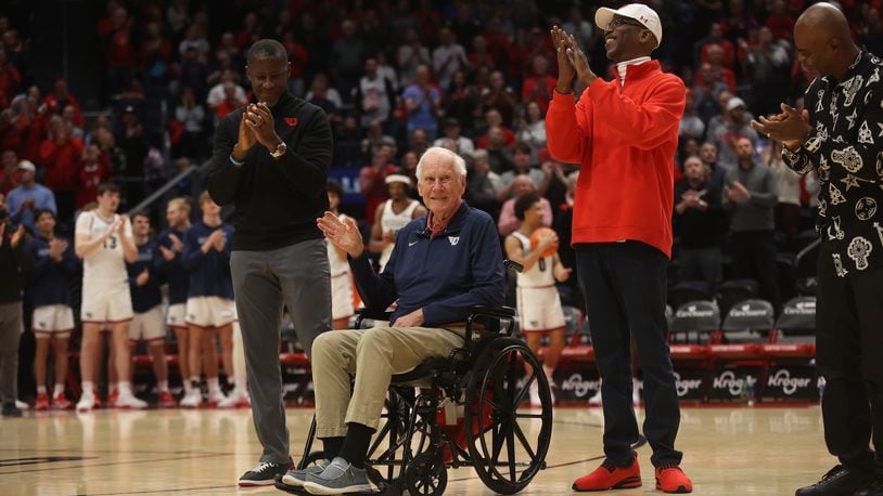 Dayton's all-time winningest coach, Don Donoher, center, is honored at halftime of a game against Grambling State on Saturday, Dec. 2, 2023, at UD Arena. Dayton's current coach Anthony Grant, left, and Roosevelt Chapman, right, were honored along with other members of Dayton's 1984 Elite Eight team. David Jablonski/Staff