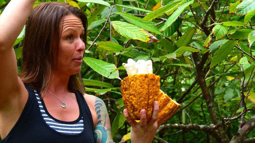Lydgate Farms Tour guide Andrea Kiser shows off the inside of a cacao fruit. (Daniel Beekman/Seattle Times/TNS)