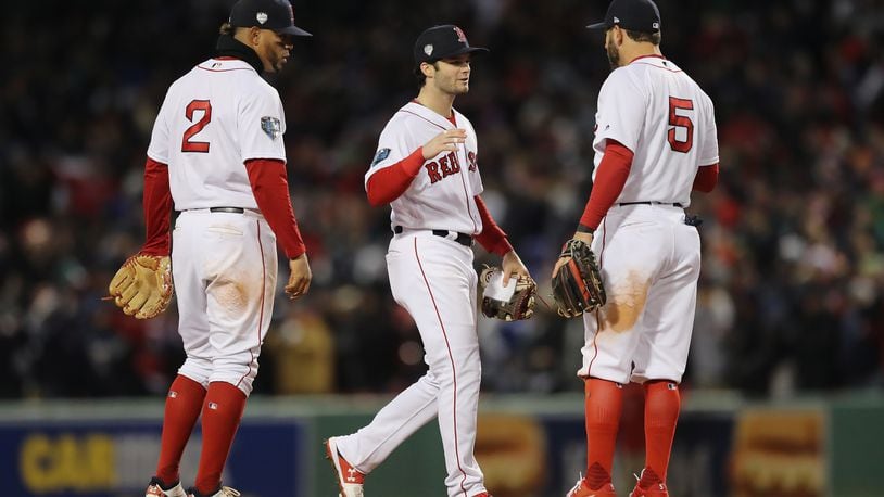 BOSTON, MA - OCTOBER 24:  Xander Bogaerts #2, Andrew Benintendi #16 and Ian Kinsler #5 of the Boston Red Sox celebrate their teams 4-2 win over the Los Angeles Dodgers in Game Two of the 2018 World Series at Fenway Park on October 24, 2018 in Boston, Massachusetts.  (Photo by Elsa/Getty Images)