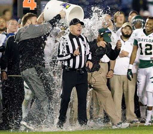 Baylor coach Art Briles is doused next to an official after Baylor defeated UCLA 49-26 in the Holiday Bowl NCAA college football game.