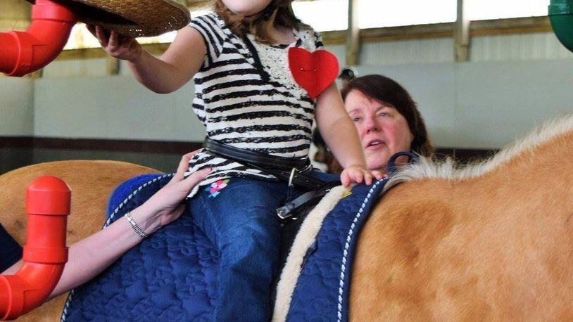 Adapted equipment, trained volunteers, certified instructors, special horses and individualized lesson plans help all of Therapeutic Riding Institute students reach their personal goals. SUBMITTED PHOTO