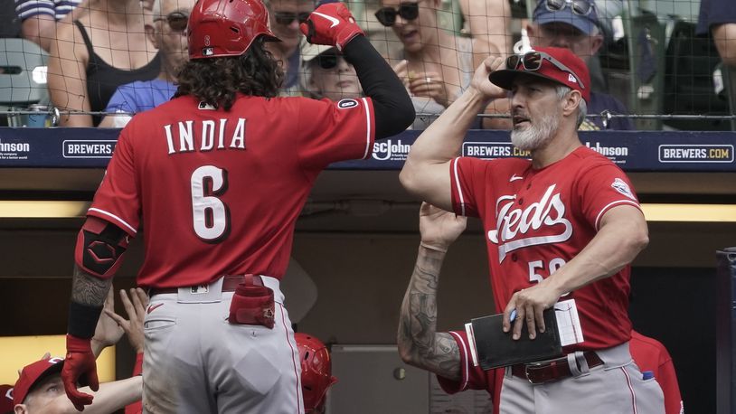 Cincinnati Reds hitting coach Alan Zinter congratlates Jonathan India on his three-run home run during the fifth inning of a baseball game against the Milwaukee Brewers Thursday, Aug. 26, 2021, in Milwaukee. (AP Photo/Morry Gash)