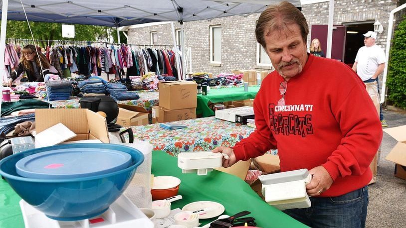 Kurt Schwitalski sets up a booth in the parking lot of the Trenton Moose Lodge for the Trenton Community Yard Sales Friday, May 20 in Trenton. The city-wide garage sales run through Sunday. NICK GRAHAM/STAFF