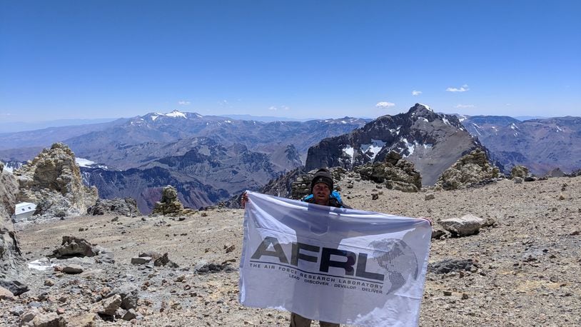Air Force Research Laboratory researcher Kevin D. Schmidt unfurls an AFRL flag on Mount Aconcagua in South America. CONTRIBUTED