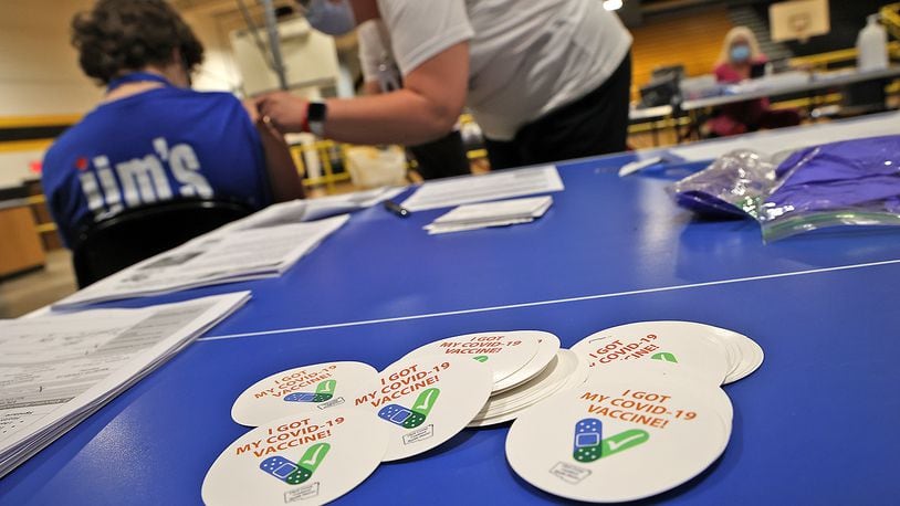 A pile of "I Got My COVID-19 Vaccine!" stickers waits for students and adults to get their vaccine shot Monday at a vaccine clinic at Shawnee High School.