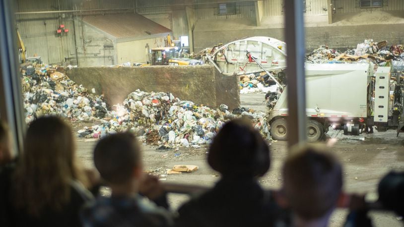 Children watch as trash is processed on the solid waste tipping floor at the Montgomery County Solid Waste facility in Moraine.