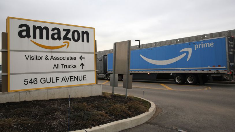 FILE - An Amazon Prime truck passes by a sign outside an Amazon fulfillment center March 19, 2020 in Staten Island, N.Y.  (AP Photo/Kathy Willens, File)