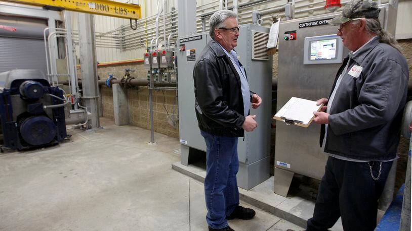 Terry Morris, Veolia Water’s project manager for the Springboro waste water treatment plant, talks with maintenance technician Rick Dalton inside the upgraded facility in 2011. FILE