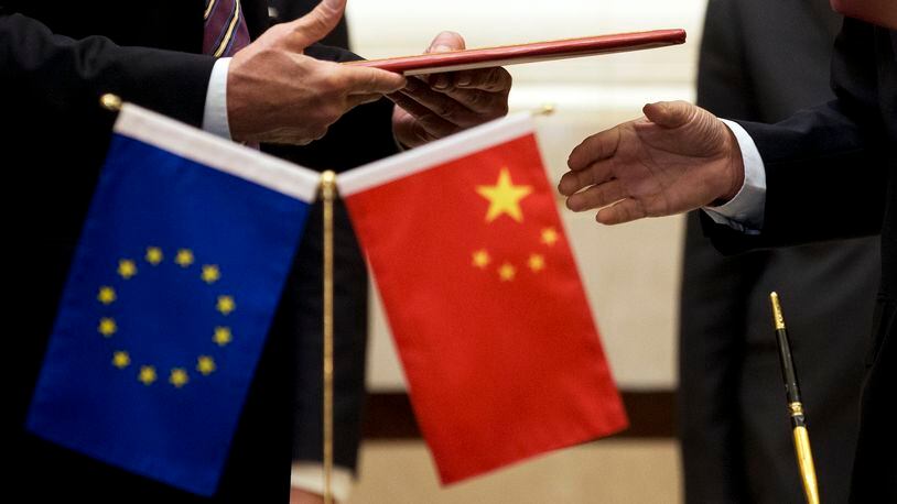 FILE - A member of European Commission, left, prepares to exchange documents with Chinese delegation at a signing ceremony after the 5th China-EU High Level Economic and Trade dialogue at Diaoyutai State Guest House in Beijing, on Sept. 28, 2015. China has accused the European Union of protectionism and “reckless distortion” of the definition of subsidies in response to a new EU investigation into Chinese wind turbine makers. (AP Photo/Andy Wong, File)