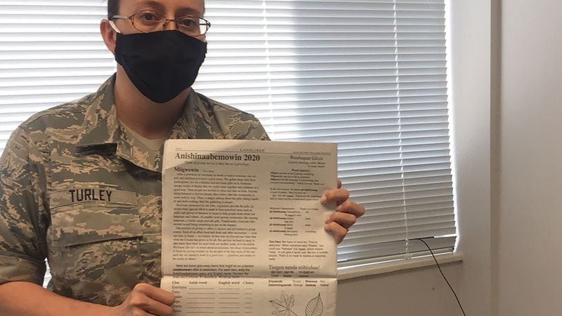 Tech. Sgt. Nicole Turley, NCO in charge, Cyber Operations Center, 88th Communications Group, Wright-Patterson Air Force Base, holds a copy of the Win Awenen Nisitotung (One Who Understands) tribal newspaper. She is a member of the Crane Clan of Sault Sainte Marie Tribe of Chippewa Indians, also known as the Ojibwa/Anishinaabeg. SKYWRIGHTER PHOTO/AMY ROLLINS