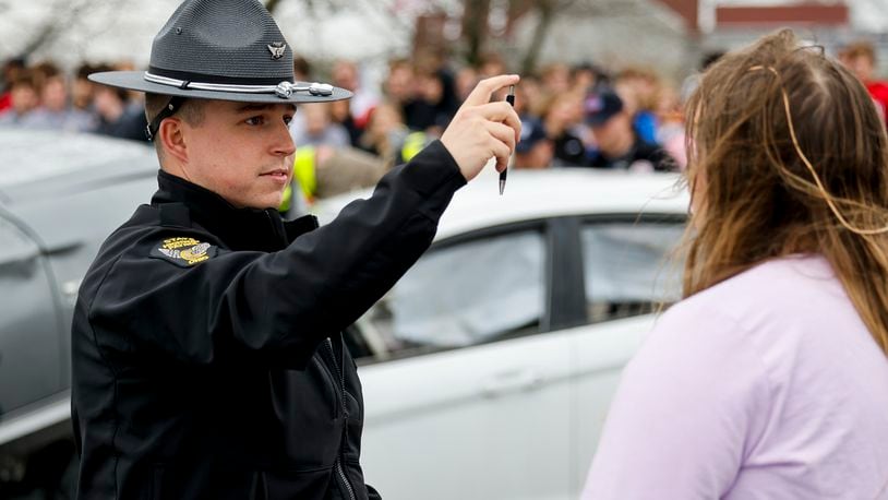 Ohio State Highway Patrol Trooper Robinette conducts a fictitious field sobriety test on a student as Fenwick High School students participate in a mock crash event in 2022. NICK GRAHAM/STAFF
