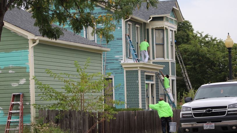 Crews on Friday worked on renovating a home in the Wright Dunbar Village neighborhood. CORNELIUS FROLIK / STAFF