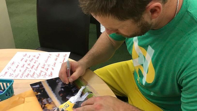 In this June 15, 2017, photo, then-Oakland Athletics catcher Stephen Vogt autographs fan mail before a baseball game between the Athletics and the New York Yankees in Oakland, Calif. Vogt recently got caught up on two years' worth of fan mail; he remembers being that child collecting autographs at every chance. (AP Photo/Janie McCauley)