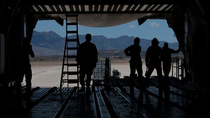 Airmen from the 21st Logistics Readiness Squadron, the 22nd Airlift Squadron watch as a K Loader is directed after putting cargo pallets onto a C-5M Super Galaxy in April. on Peterson Air Force Base, Colo. Peterson AFB photo