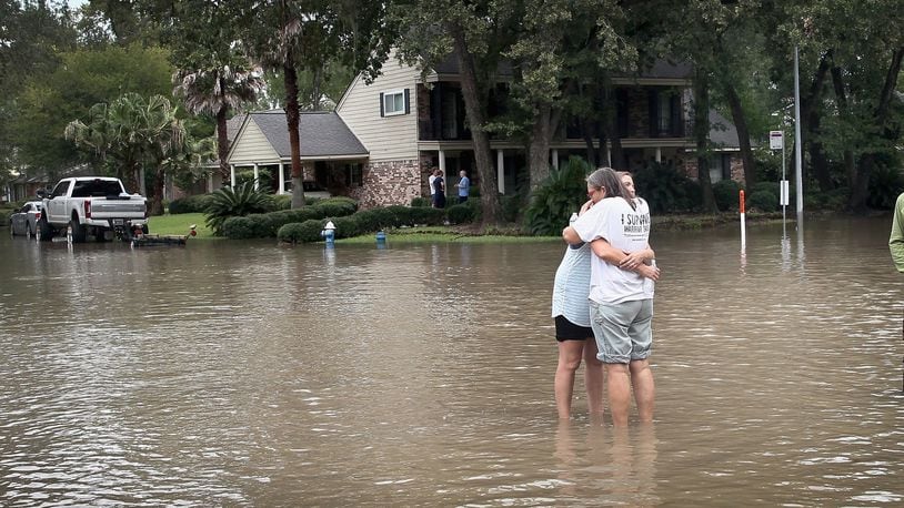 HOUSTON, TX - AUGUST 30: Friends reunite in the middle of a flooded intersection as water continues to rise in their neighborhood following Hurricane Harvey on August 30, 2017 in Houston, Texas. Harvey, which made landfall north of Corpus Christi August 25, has dumped nearly 50 inches of rain in and around Houston. (Photo by Scott Olson/Getty Images) *** BESTPIX ***
