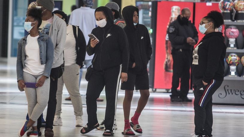 Around 300 people went shopping Tuesday morning at the Dayton Mall. The doors opened at 11 a.m. for 50 people waiting at the doors. About half the stores appeared to be open and about half the shoppers in the mall were wearing masks. JIM NOELKER/STAFF