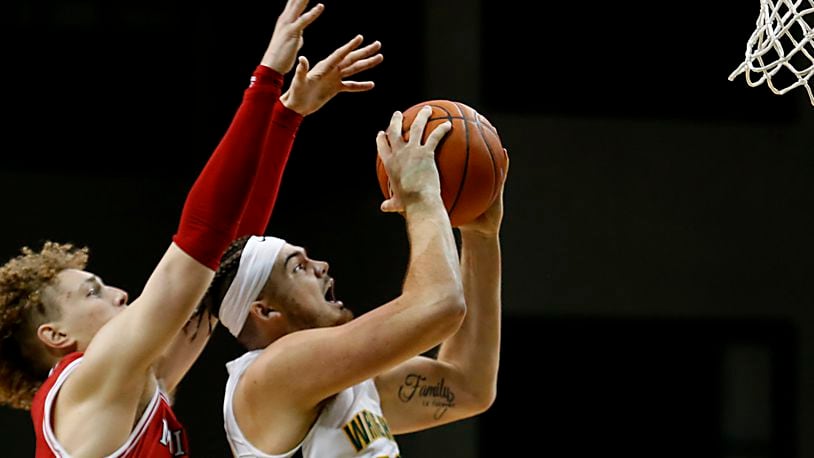 Wright State forward Grant Basile scores against Miami forward Javin Etzler during a mens basketball game at the Nutter Center in Fairborn Saturday, Dec. 5, 2020. E.L. Hubbard/CONTRIBUTED