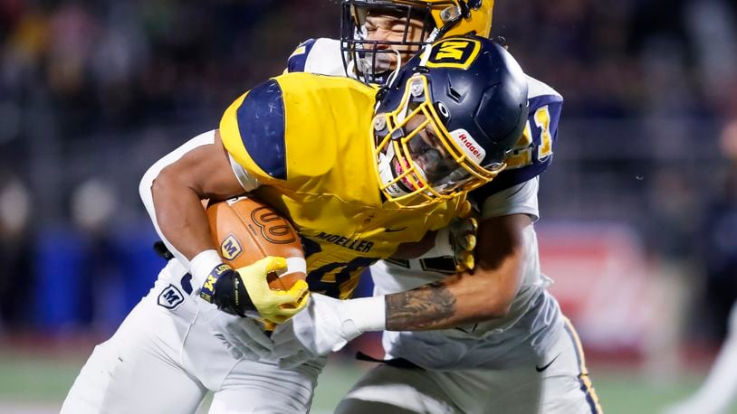 Moeller's Jordan Marshall is tackled by Springfield's Teryon Holt in the 2022 Division I state semifinals at Piqua. Michael Cooper/CONTRIBUTED