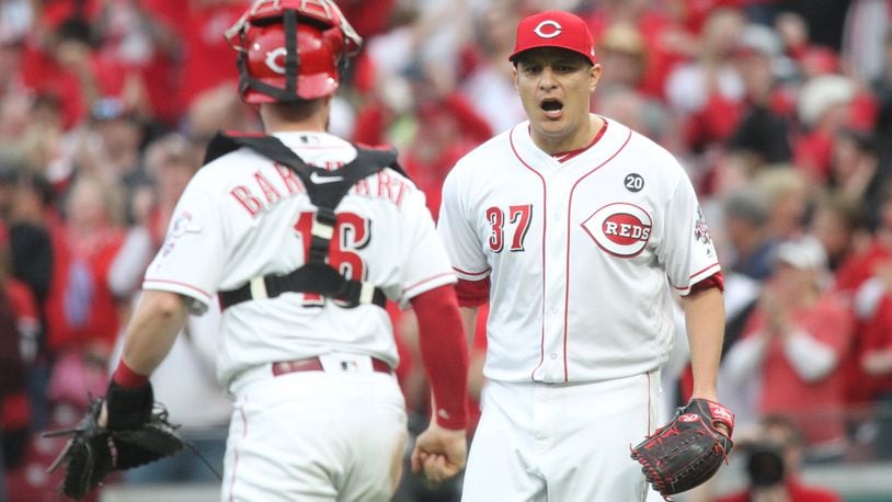 Caption: Reds reliever David Hernandez, left, reacts after recording the final out of a victory against the Pirates as catcher Tucker Barnhart watches on Opening Day on Thursday, March 28, 2019, at Great American Ball Park in Cincinnati. David Jablonski/Staff