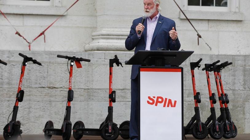 Greater Dayton RTA Chief Executive Officer Mark Donaghy with Spin Electric Scooters at Courthouse Square on Wednesday. RTA held a launch party to introduce the scooters to the city of Dayton. Donaghy along with residents and other civic leaders rode the scooters around two city blocks.   TY GREENLEES / STAFF