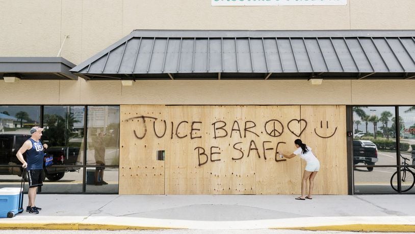 Paige Oldenburg spray paints the wood outside her juice bar in Jensen Beach, Fla., Sept. 8, 2017. The National Hurricane Center said Irma remained “extremely dangerous,” with winds of 150 miles per hour, and the Florida Keys were at risk of “life-threatening inundation.” It is expected to hit the Florida Keys and South Florida by Saturday night. (Jason Henry/The New York Times)