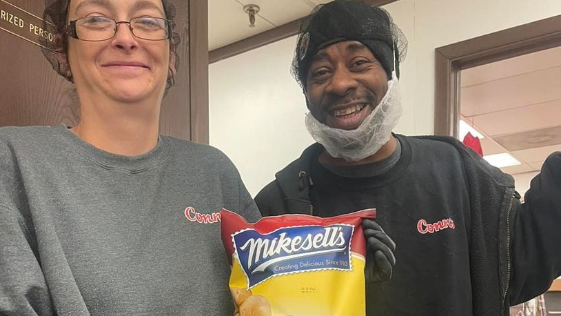 Conn's packing room Supervisor Tomorrow and head Fryer Technician Mel displaying the first Mikesell's bag of chips off the line at Conn’s Zanesville plant. Conn's Facebook photo