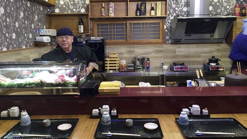 In this Feb. 19, 2017, photo provided by Paektu Cultural Exchange, Japanese sushi chef Kenji Fujimoto works behind the counter of his new restaurant in Pyongyang, North Korea. Fujimoto, a Japanese chef famous for working for North Korea's late leader Kim Jong Il, has returned to Pyongyang and opened the sushi restaurant. (Paektu Cultural Exchange via AP)