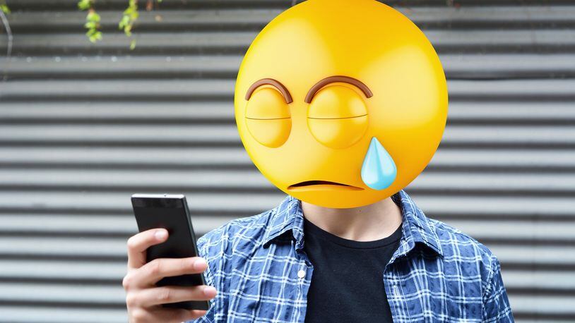 Emoji head man using a smartphone. (Dreamstime/TNS)