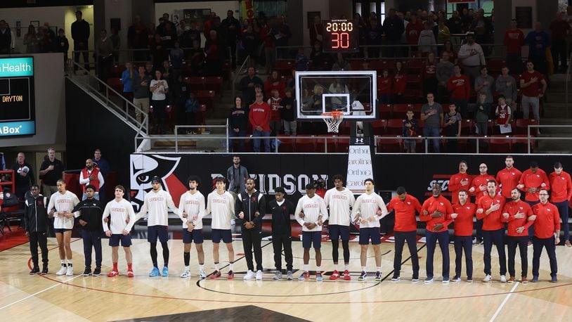 Dayton players and coaches stand for the national anthem before a game against Davidson on Saturday, Dec. 31, 2022, at Belk Arena in Davidson, N.C. David Jablonski/Staff