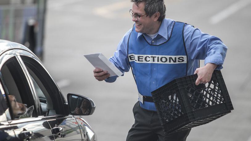 Montgomery County Board of Elections clerk Mike Miller collects ballots on Third Street in Dayton on Tuesday, April 28, 2020. JIM NOELKER / STAFF