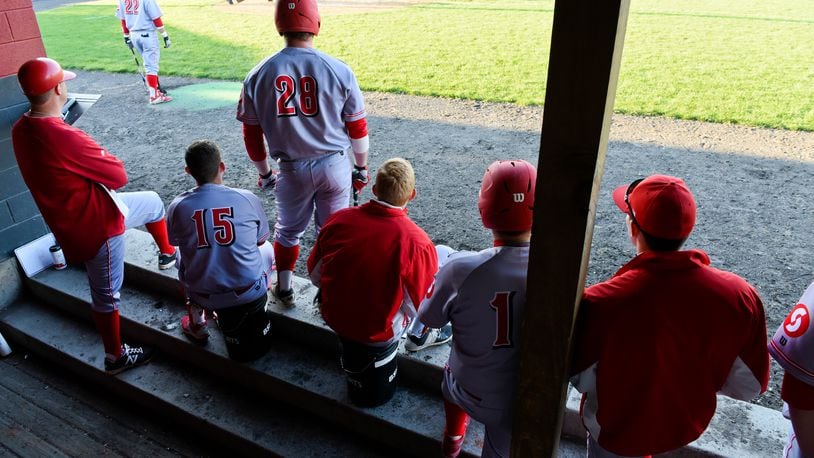 Sinclair baseball coach Steve Dintaman, left, and the team watch as teammates bat during a game against Miami Hamilton in this file photo from Foundation Field in Hamilton. Sinclair College’s board of trustees voted last week to suspend sports programs for another academic year due to the pandemic and left open the prospect of doing away with intercollegiate athletics entirely to focus on other priorities. NICK GRAHAM/STAFF