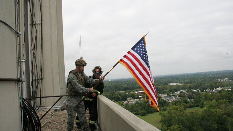 Maj. Tyler Johnson, 788th Civil Engineer Squadron commander, left, and Chief Jacob King of the Wright-Patterson Air Force Base Fire Emergency Services Department, climb the 13 stories and 253 steps of the tower. At the top, the pair post the flag. (U.S. Air Force photo/Tedd Pitts)