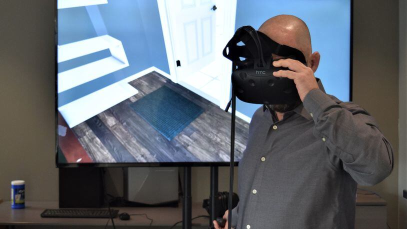 Miamisburg-headquartered Marxent develops software to help consumers visualize furniture at stores like La-Z-Boy and Macy’s using augmented and virtual reality. Co-founder and chief technology officer Barry Besecker uses virtual reality to look at furniture in a home. STAFF PHOTO / HOLLY SHIVELY