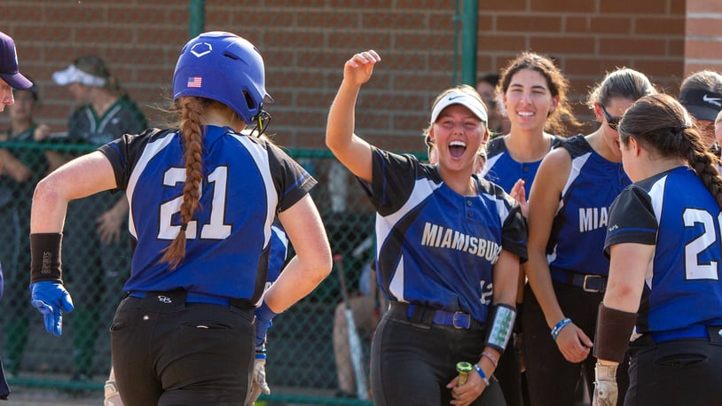 Miamisburg's Jayleigh Thomas and her teammates greet Alley Haas after the first of her two home runs in Thursday's 11-8 Division I district final victory over Mason at Hamilton High School. CONTRIBUTED/Jeff Gilbert