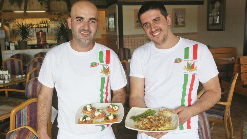 Labi Troni and Mensur Demnika, chefs at Palermo’s Italian Restaurant in West Chester Twp., hold dishes capresi salad and veal marsala at the restaurant, Wednesday, May 26, 2015. GREG LYNCH / STAFF