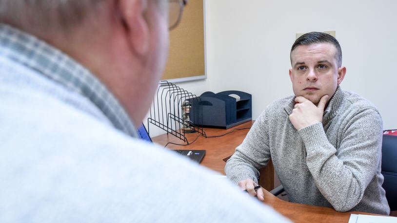 Casey James, right, service officer with the Butler County Veterans Service Commission, meets with a client in the Middletown branch office on Breiel Boulevard. NICK GRAHAM/STAFF