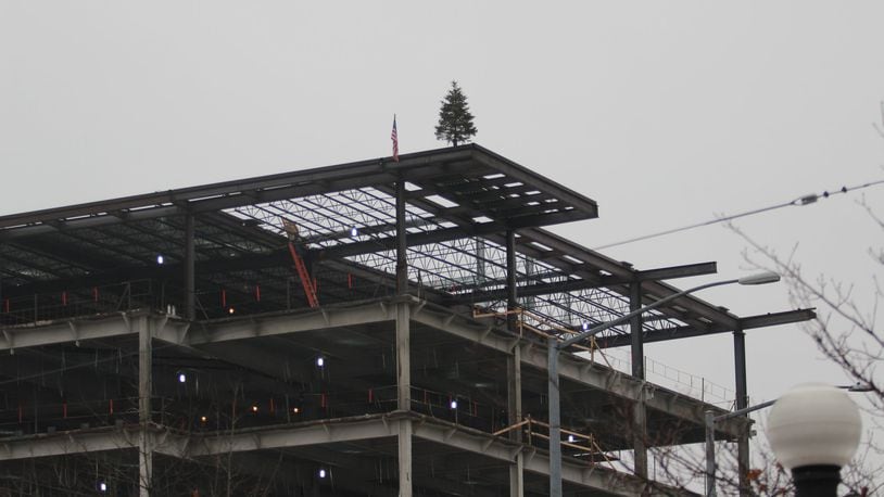 A flag and tree were placed on top of the new CareSource building under construction in Dayton by Danis as part of a topping off ceremony. KAITLIN SCHROEDER/STAFF