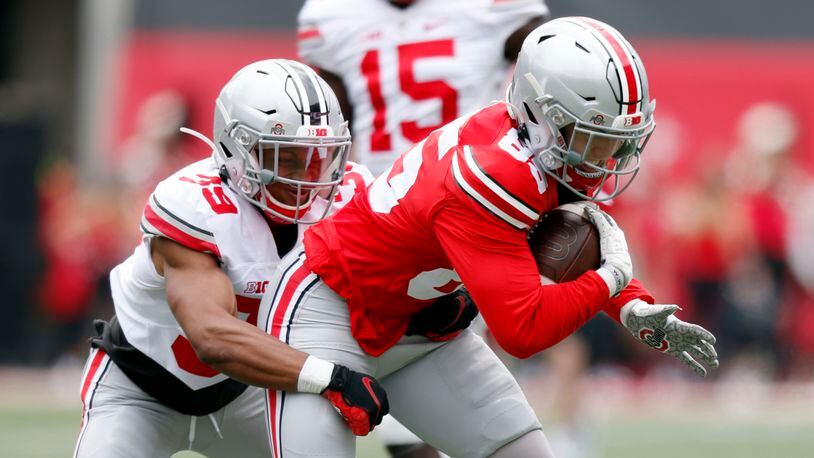 Ohio State wide receiver Austin Kutscher, right, is stopped by defensive back Andrew Moore during the Buckeyes' spring NCAA college football game in Columbus, Ohio, Saturday, April 17, 2021. (AP Photo/Paul Vernon)