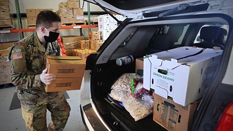 A member of the National Guard loads fresh food into the back of a vehicle at The Foodbank April 2. MARSHALL GORBYSTAFF