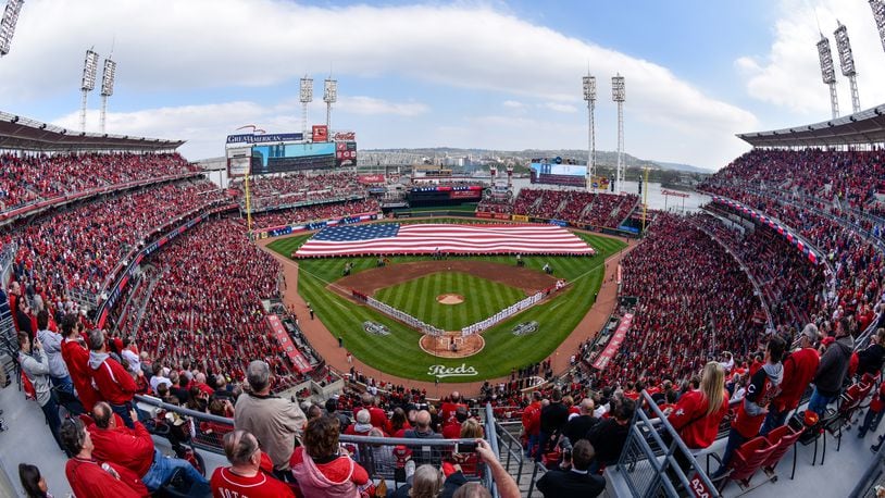 Thousands of fans stand during the National Anthem prior to the start of the Reds Opening Day game against Philadelphia Monday, April 4 at Great American Ball Park in Cincinnati. NICK GRAHAM/STAFF