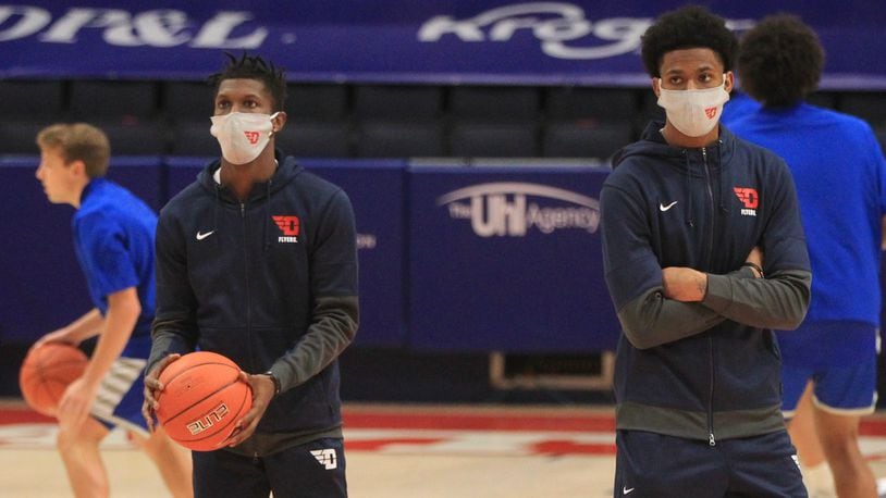 Dayton's Dwayne Cohill and Elijah Weaver watch the team warm up before a game against Eastern Illinois on Tuesday, Dec. 1, 2020, at UD Arena. David Jablonski/Staff