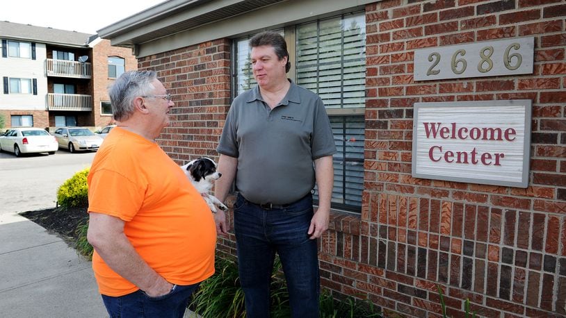 Cobblegate Square Apartments Property Manager Dave Cook, right, talks with resident Larry May and his dog, Panda, Friday morning June 17, 2022. MARSHALL GORBY\STAFF